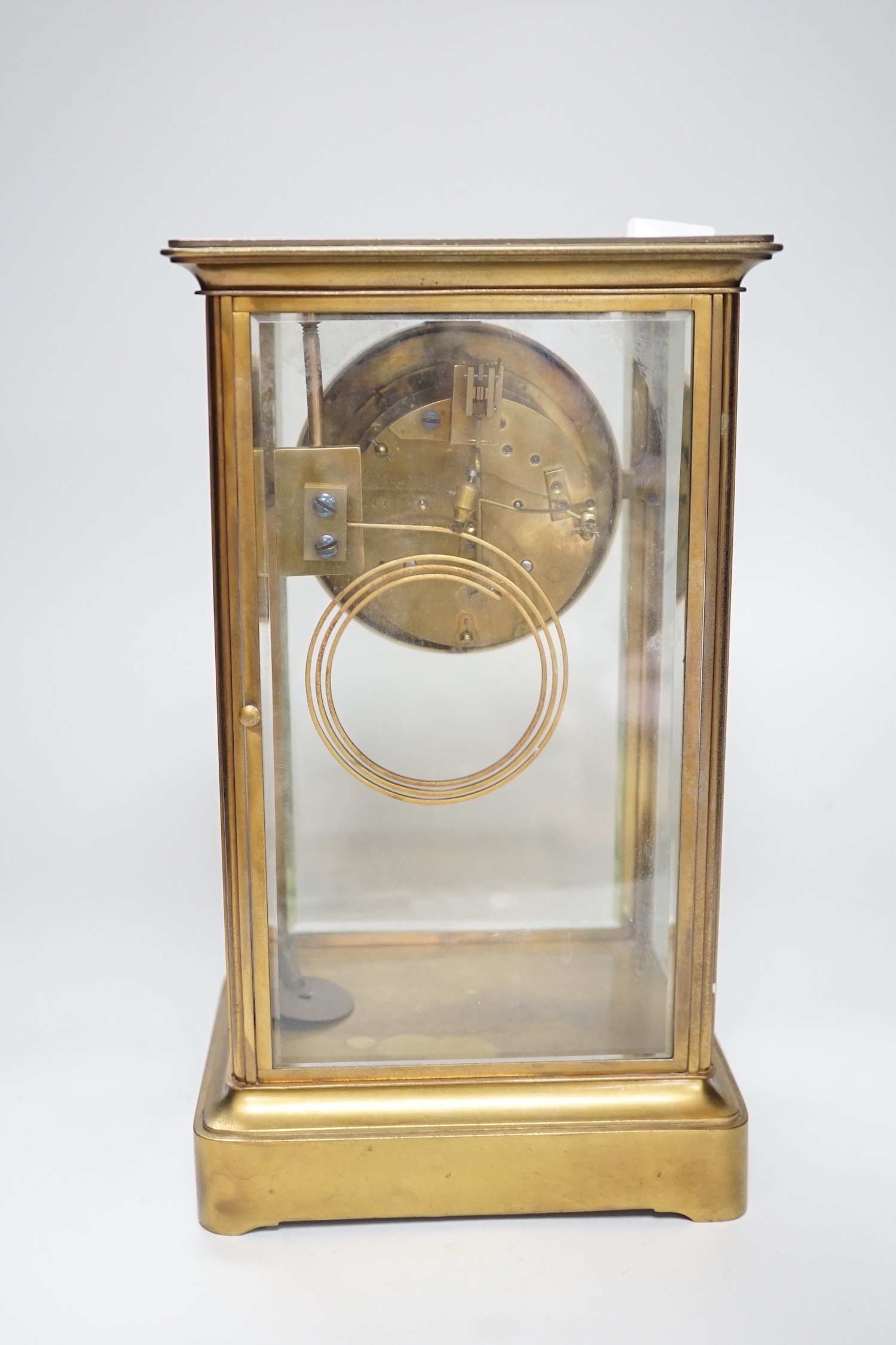 An Edwardian brass four-glass mantel clock with pendulum, presentation plaque to base, 30cm tall